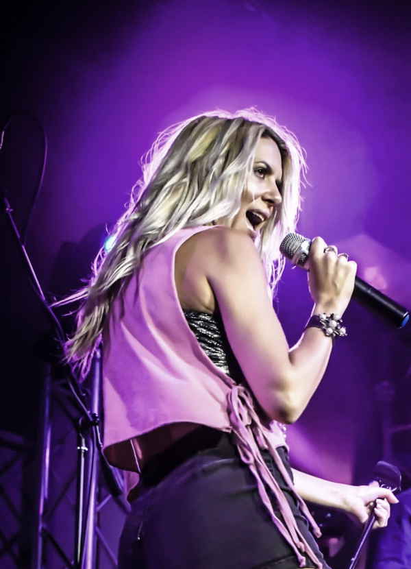 Professional picture of our female vocalist for events looking to audience while passionately singing onstage | Altus Entertainment